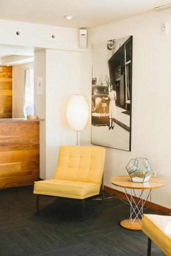 a living room with a yellow chair and a picture on the wall at Modern Hotel in Boise
