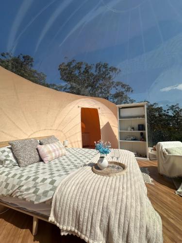a bedroom with a bed and a table at Romantic Stargazing Dome - Beyond Bubbles in Kulnura