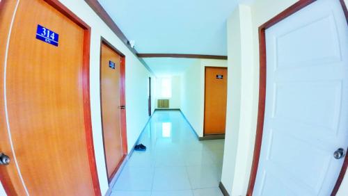 an empty corridor in an office building with orange doors at เอสดี ดี พี อพาร์ทเม้นต์ in San Kamphaeng
