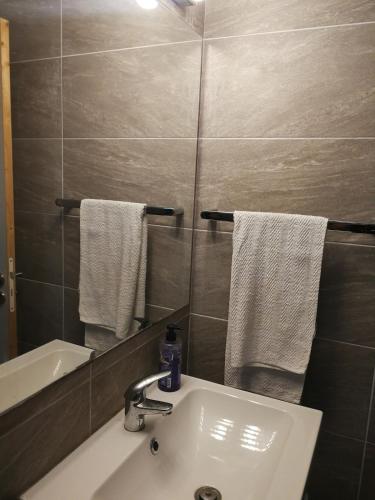 a bathroom with a sink and a mirror and towels at Villa with big garden in Athens