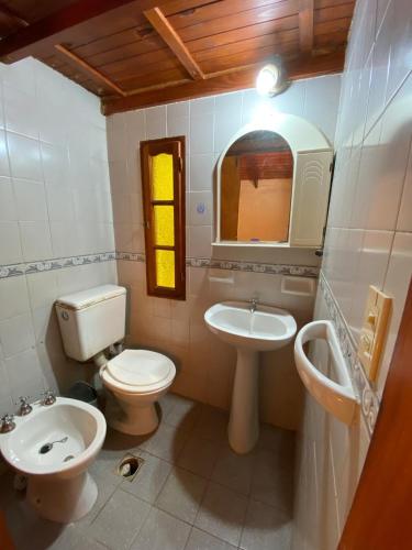 a bathroom with a toilet and a sink and a mirror at Casa Mitre en El Paso in Paso de la Patria