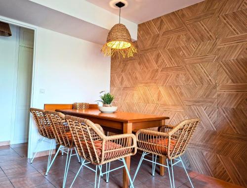 a dining room with a wooden wall with a table and chairs at Maison 3 chambres - 6-8 personnes - piscine chauffée - jacuzzi - internet - parking - Idéal familles & pros in Monflanquin