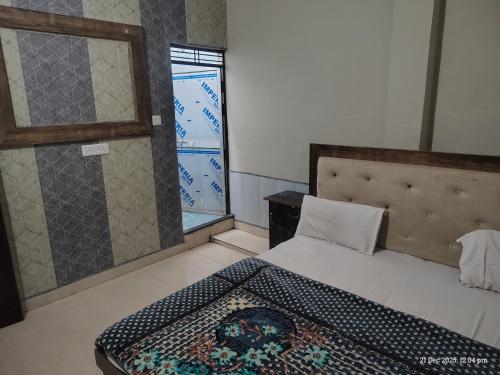 a bedroom with a bed and a window at Raghunandan dham in Chitrakoot
