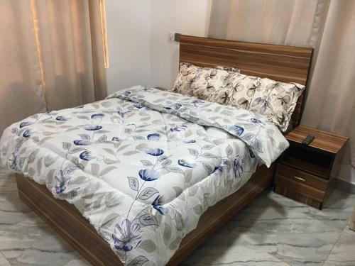 łóżko z niebiesko-białą kołdrą w obiekcie EMA Apartment w mieście Kokrobite