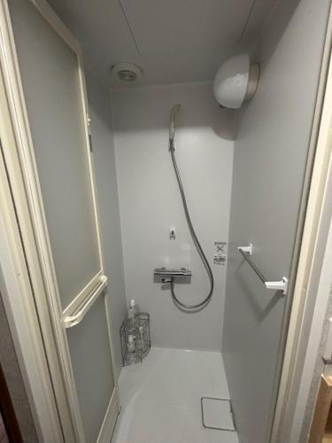 a bathroom with a shower and a toilet at 塩浜駅前店おうち二階 in Yokkaichi