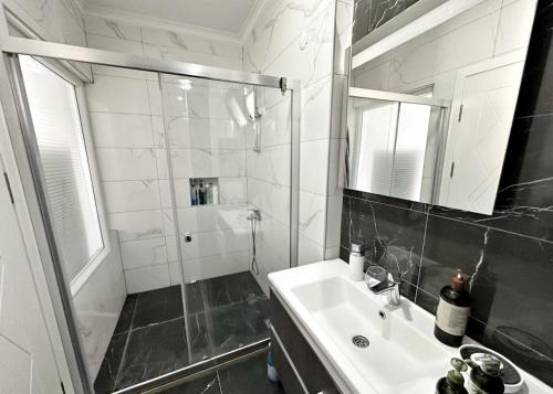 a bathroom with a shower and a sink and a mirror at Serenity Hideaway Hisarönü in Fethiye
