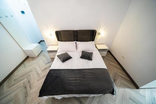 a bedroom with a bed with black sheets and pillows at Sunrise Rooms in Bucharest
