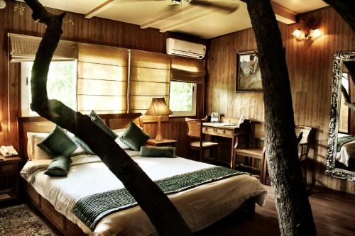 a bedroom with a bed and a table and chairs at The Tree House Resort, A Club Mahindra Associate in Jaipur