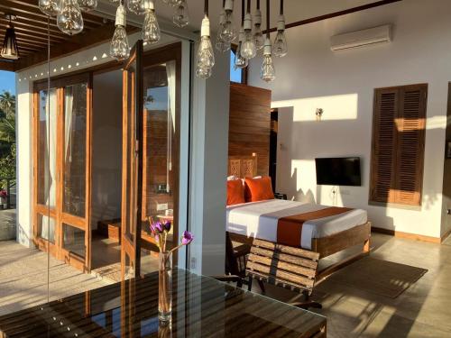 a bedroom with a bed and a table and a television at SereneVbes - Kandy in Kandy