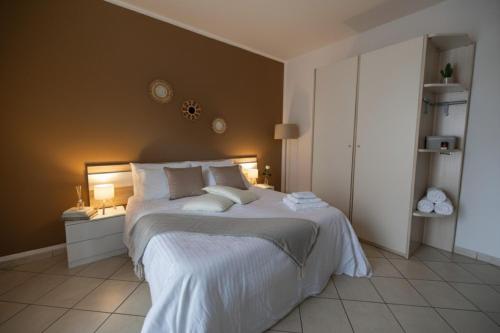 a bedroom with a large bed with white sheets and pillows at Suite 64 in Saviano