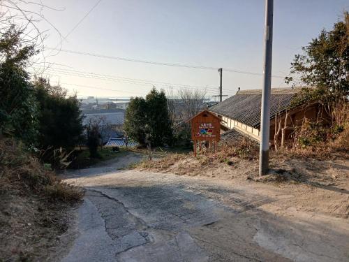 a dirt road next to a building with a pole at 五色の家 in Sumoto