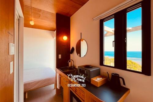 a bedroom with a bed and a sink and a window at OceansideRanch Miyazaki in Miyazaki