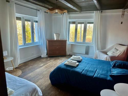 a bedroom with a bed and a dresser and windows at Le Gîte de Hildegarde in Granges-Aumontzey