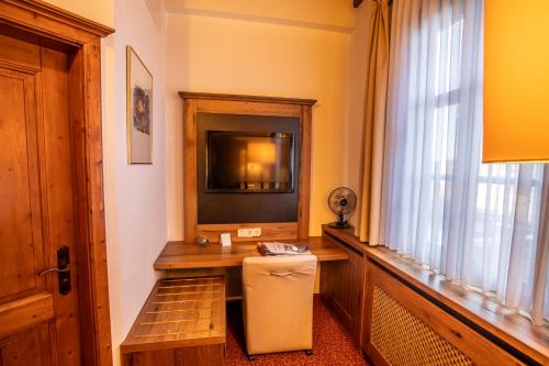 a room with a television and a small refrigerator at Burg Colmberg Hotel in Colmberg