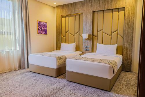 two beds in a hotel room with a window at فندق ترى النزهة -Tura Hotel AlNuzha in Riyadh