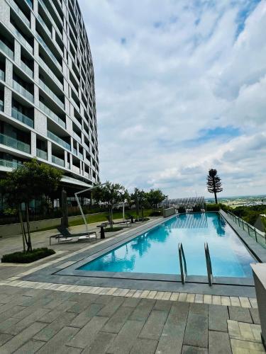 a large swimming pool next to a tall building at Executive Studio at Ellipse Galileo - Waterfall in Midrand