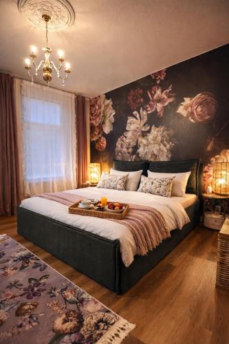 a bedroom with a large bed with a floral wall at N&N Altbau-Apartments Schwerin nähe Schloss & Zentrum in Schwerin