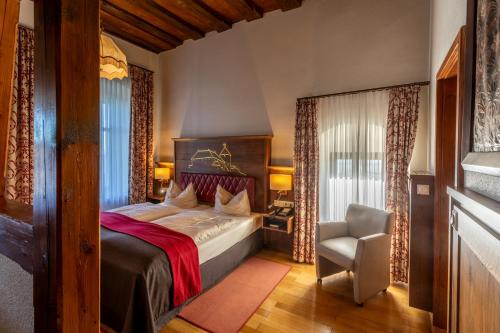 a bedroom with a bed and a chair in a room at Burg Colmberg Hotel in Colmberg