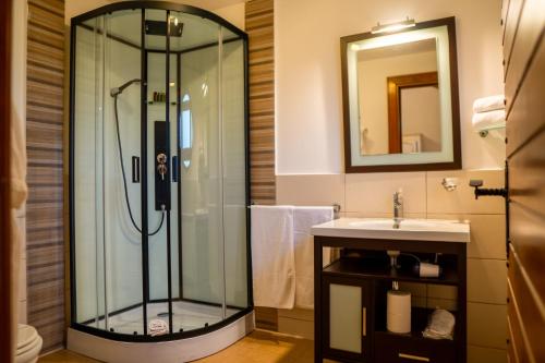 a bathroom with a shower and a sink at Acacia Village in Ogrezeni