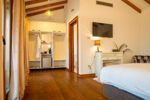 a bedroom with a bed and a tv on the wall at Acacia Village in Ogrezeni