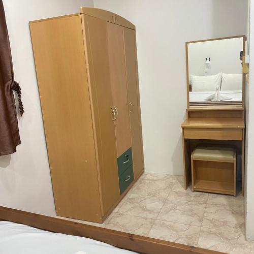 a large wooden cabinet next to a vanity with a mirror at Good Villa by Saran in Krabi