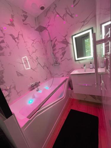 a pink bathroom with a tub and a sink at All in relaxation in Toulouse