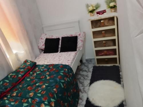 een kleine slaapkamer met een bed en een boekenplank bij UJ Apartment in Abu Dhabi