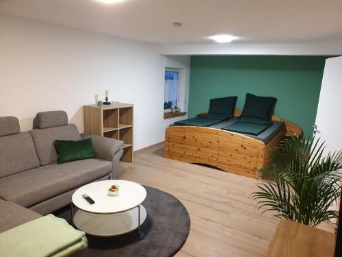 a living room with a couch and a bed at Ferienwohnung zur Honigschleife in Langweiler