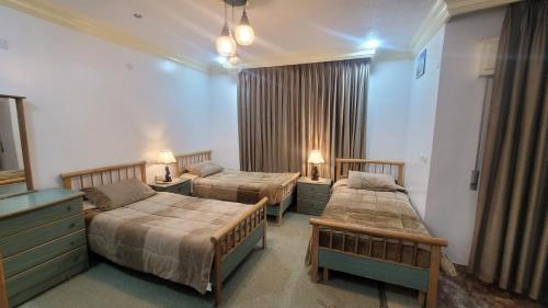 a hotel room with two beds and a couch at Zaytouna Farm in Ajloun