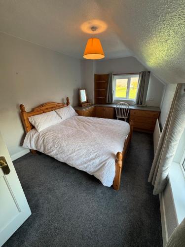 a bedroom with a bed and a window at Magilligan Lodge in Bellarena Station