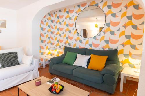 a living room with a green couch and a mirror at A pie de playa con Ascensor y Workspace By DelucaCo in Altea
