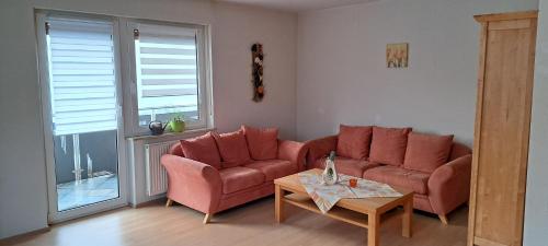 a living room with a red couch and a table at Ferienwohnung Lene im Lauertal - Rhön in Maßbach