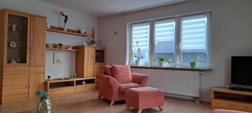 a living room with a chair and a television at Ferienwohnung Lene im Lauertal - Rhön in Maßbach
