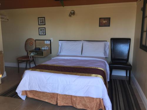 um quarto de hotel com uma cama e uma cadeira em Motel Montgolfière JP em Saint-Jean-sur-Richelieu