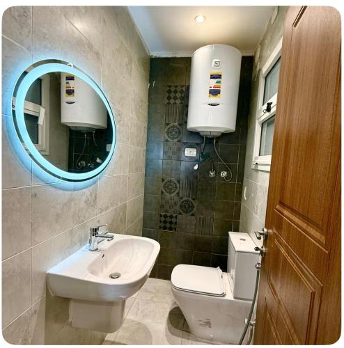 a bathroom with a sink and a toilet and a mirror at شقة فندقيه بمدينتي in Madinaty