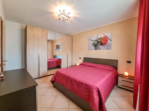 a bedroom with a red bed and a mirror at Appartamento Roverella in Rovigo