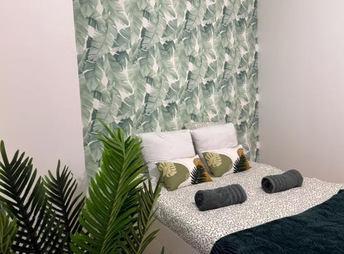a bedroom with a bed with pillows and a plant at La casa Rio de Janeiro - parking & confort in Trignac
