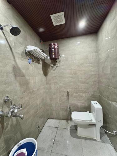 a bathroom with a toilet and a phone on the wall at Hotel Sambhavi in Hisua