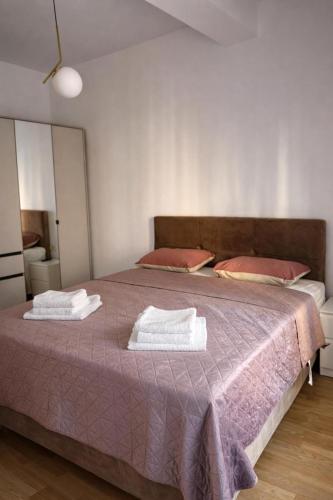 a bedroom with a bed with two towels on it at Bozovic Apartman 2 in Budva