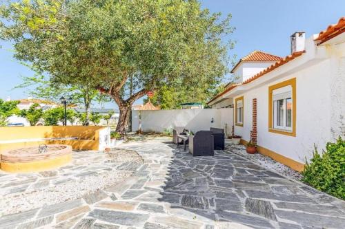 a patio with a tree and a house at O Mundo da Lua in Azeitao