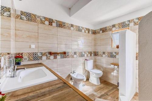 a bathroom with a tub and a toilet and a sink at O Mundo da Lua in Azeitao