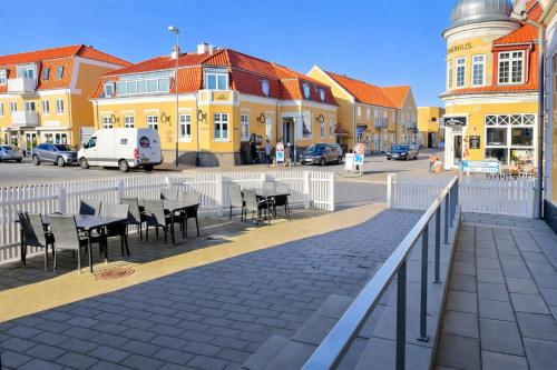 a boardwalk with tables and chairs in front of buildings at GBH - Central Townhouse in Skagen in Skagen
