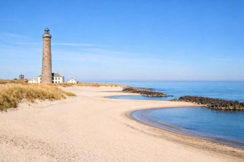 a lighthouse on the shore of a beach at GBH - Central Townhouse in Skagen in Skagen