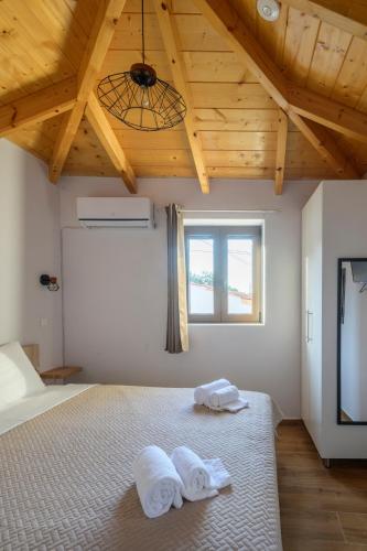 a bedroom with a bed with towels on it at Voidοkilia rooms in Petrochori
