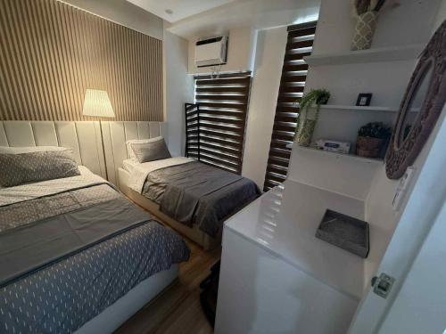 a small bedroom with two beds and a window at Miyu's Staycation Place in Biñan