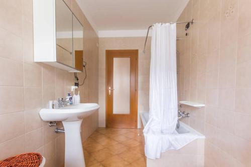 baño con lavabo y cortina de ducha en Comano Terme Apart en Comano Terme