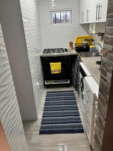 a kitchen with a stove and a rug at Casa Serrana in Penhas da Saúde
