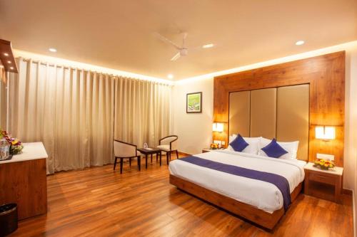 a hotel room with a large bed and a desk at Hotel Gentleman Plaza in Alleppey