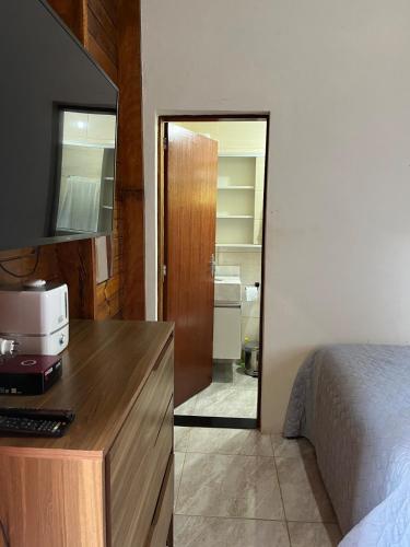 a bedroom with a bed and a dresser with a computer on it at Refúgio Bosques de Itu in Itu