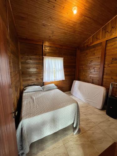a bedroom with two beds in a wooden cabin at Refúgio Bosques de Itu in Itu